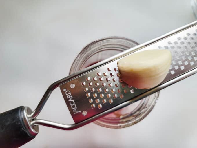 Grating onion over container.