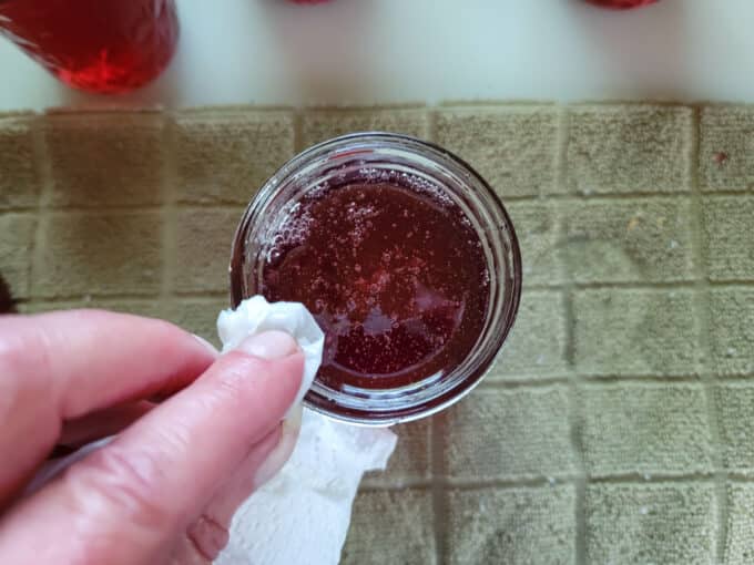 Wiping rim of jar.