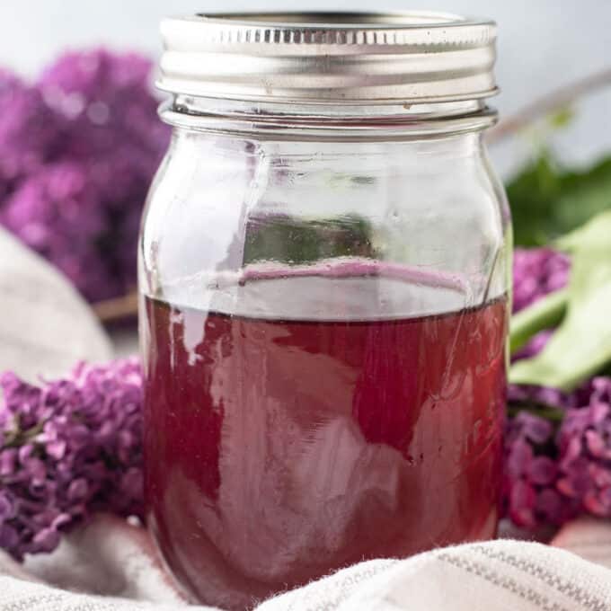 Close up of lilac syrup in jar.