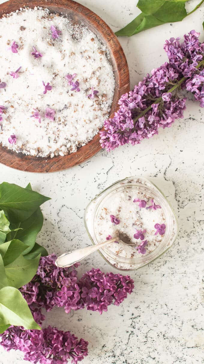 Lilac sugar in jar with a plate of sugar next to it.