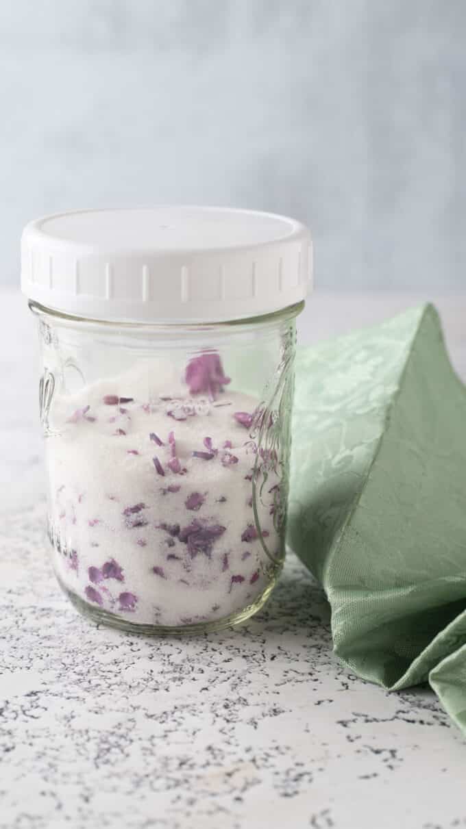 Lilac sugar in a jar with a white cap.