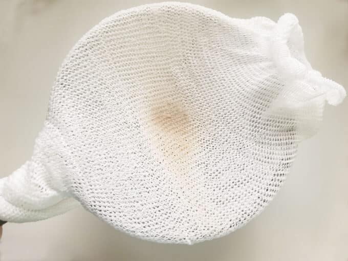 Cheesecloth lined strainer.