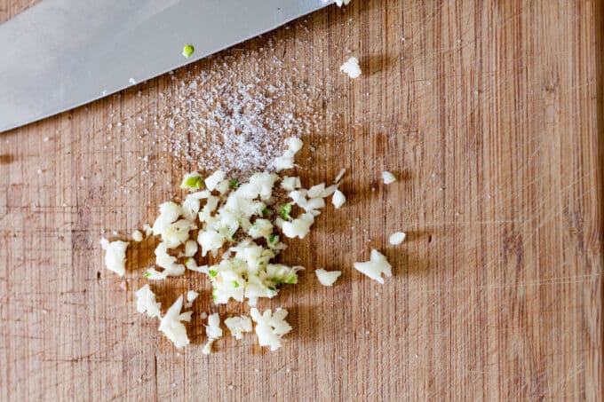 Minced garlic on board with a little salt.