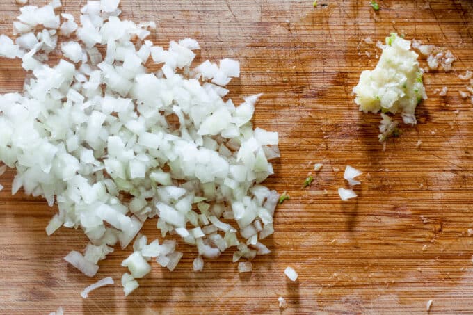 Minced onion and pasted garlic on cutting board.