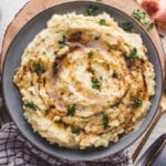 Mashed potatoes in gray bowl with brown butter.