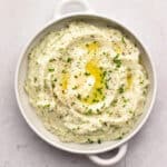 Mashed cauliflower in a white casserole dish.