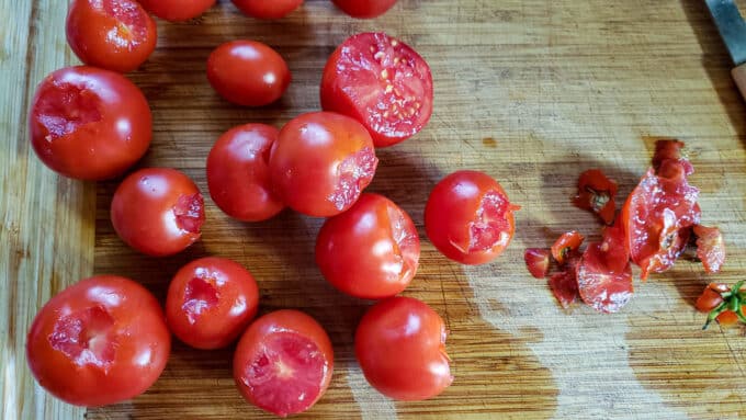 Cored and trimmed tomatoes on cutting board.