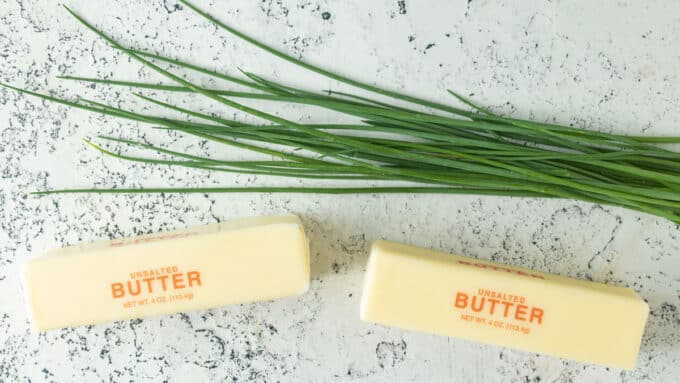 Fresh chives and butter on white background.