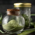 Dehydrated garlic scape powder in round mason jar.