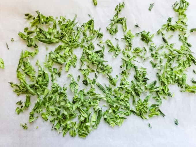 Dehydrated garlic scapes on parchment paper.