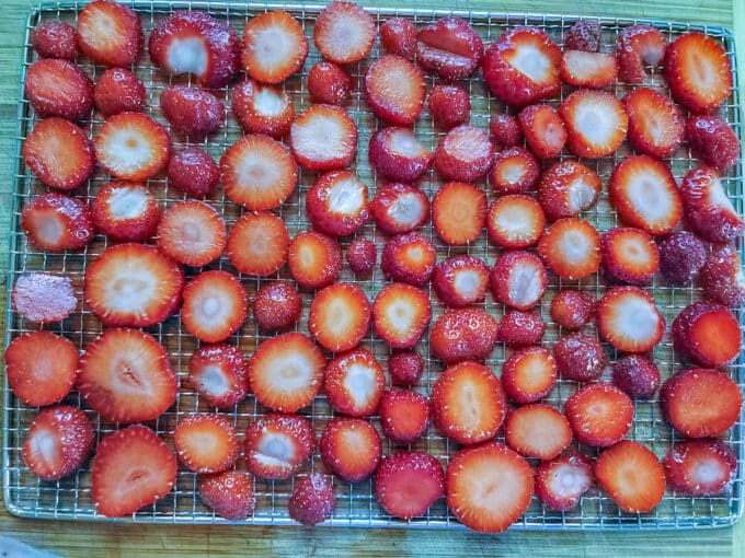 Strawberries on dehydrator rack sliced crosswise.
