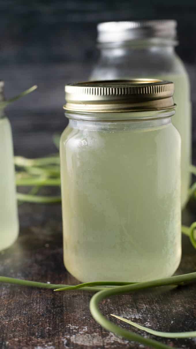 Light green garlic scape broth in mason jar.