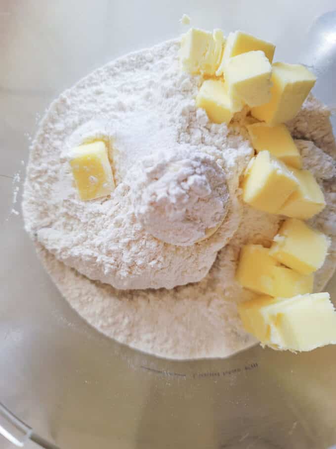 Butter added to flour in food processor bowl.