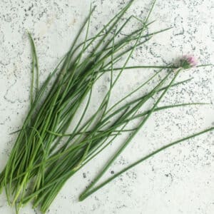 Chives on white board with flowers.