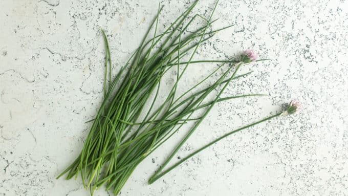 Chives on white board with flowers.