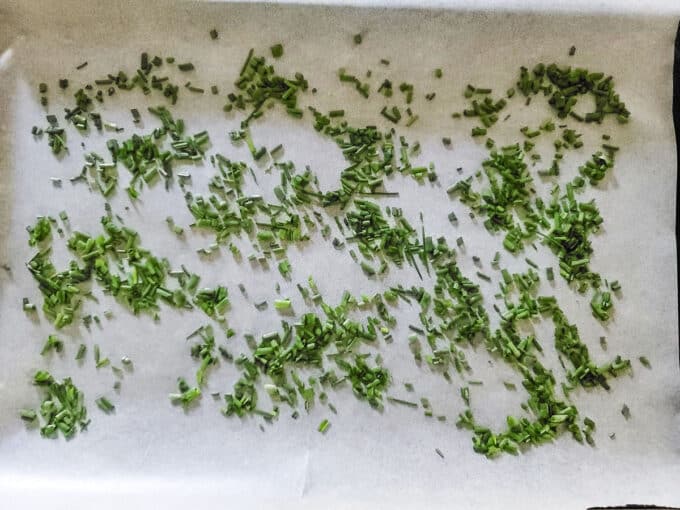 Chopped chives on parchment paper.
