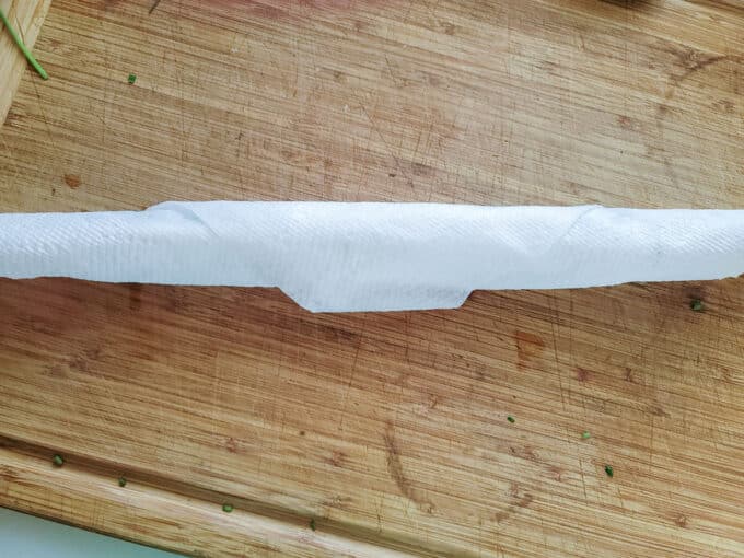 Fresh chives rolled up in paper towel.