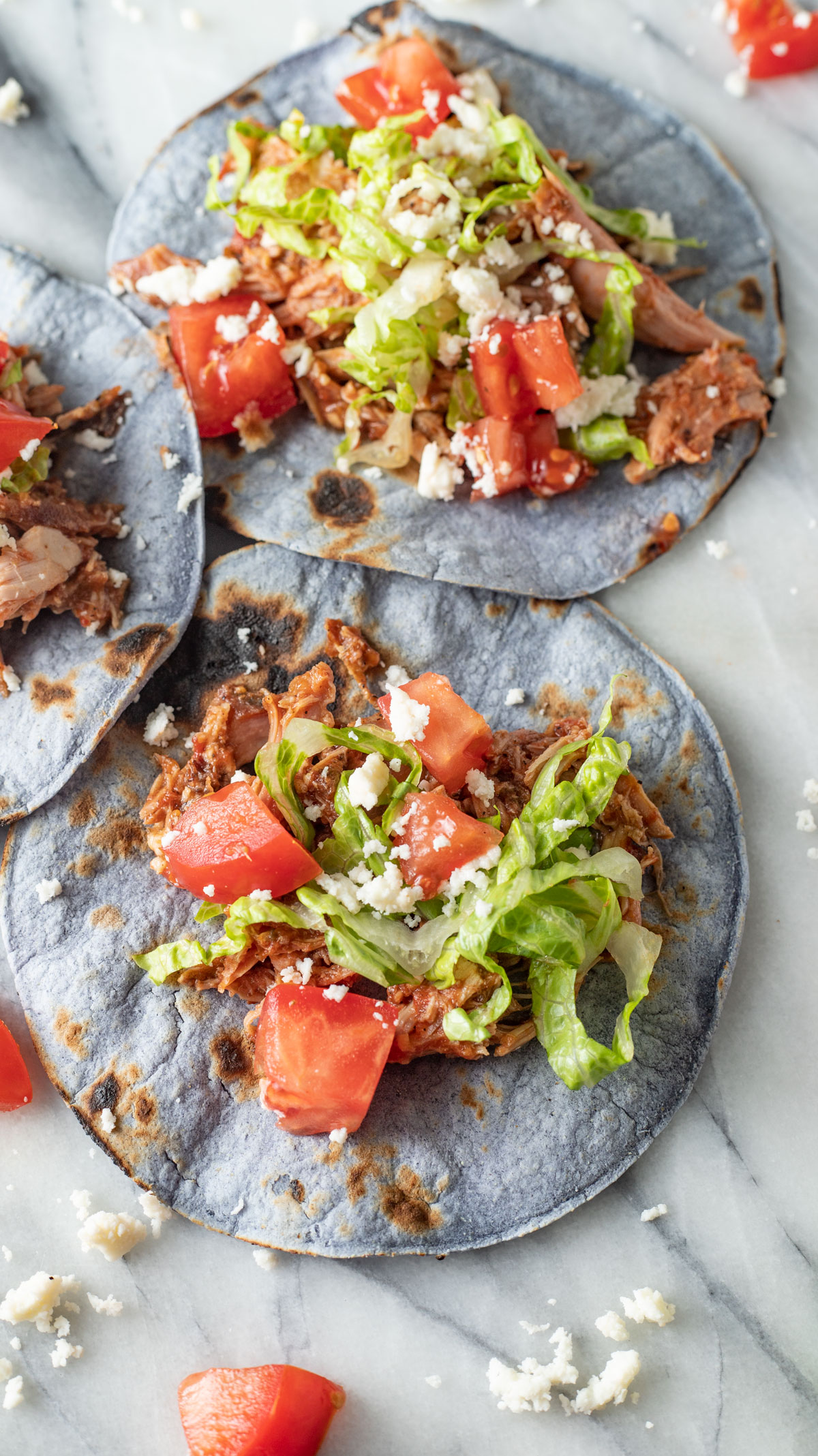 Two pheasant tacos on marble board.