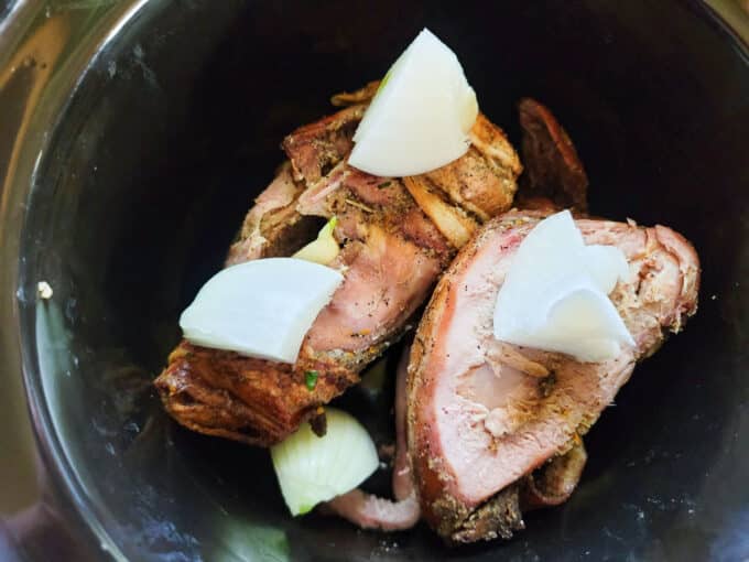 Onions and garlic cloves added to pheasant.