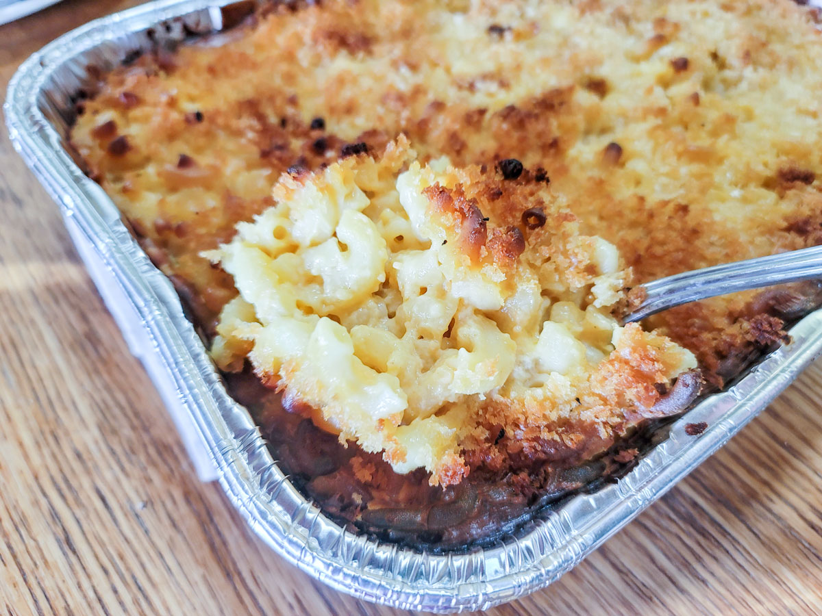 Spoon scooping out golden brown mac and cheese.