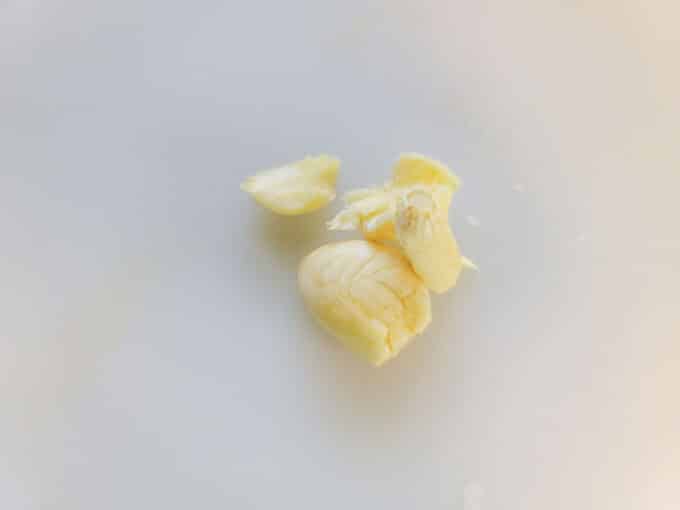 Smashed garlic on white board.