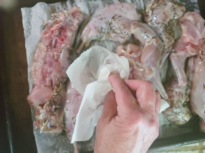 Patting meat dry with paper towel.
