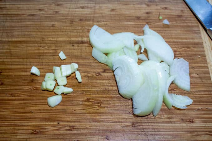 Chopped onion and garlic on board.