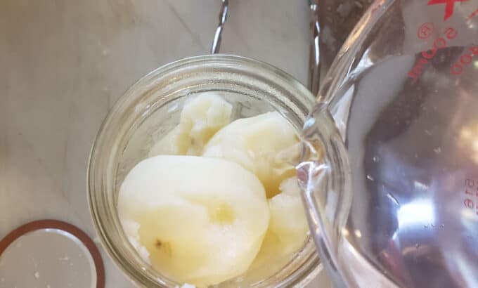 Adding boiling water to jar.