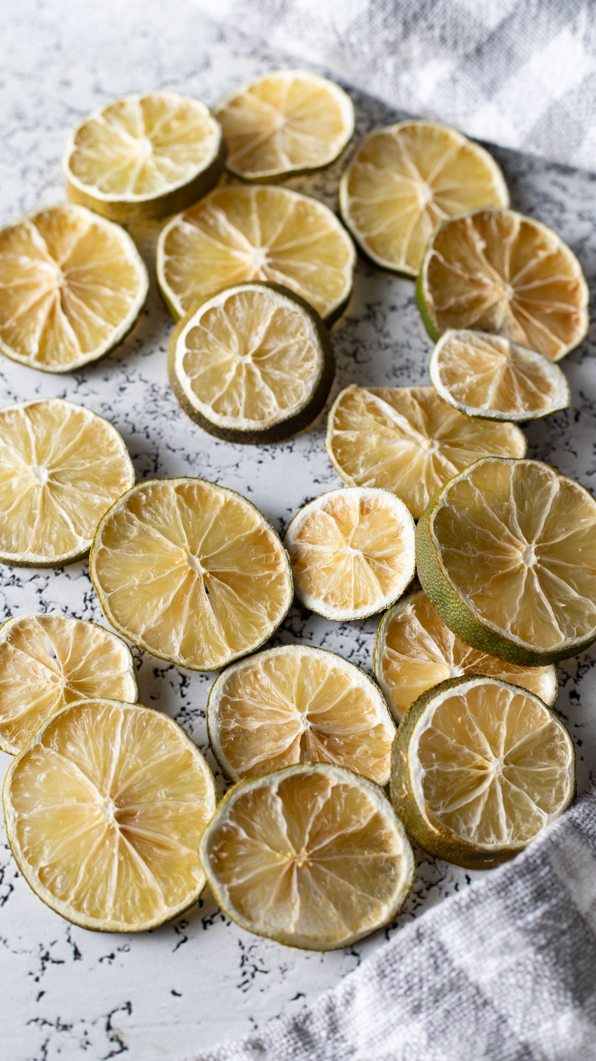 Dried limes scattered on light background.