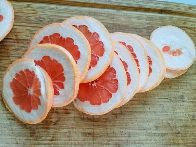 Sliced grapefruit on cutting board.