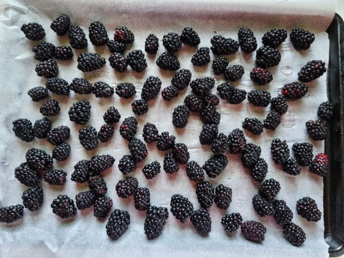 Berries arranged on parchment lined baking sheet.