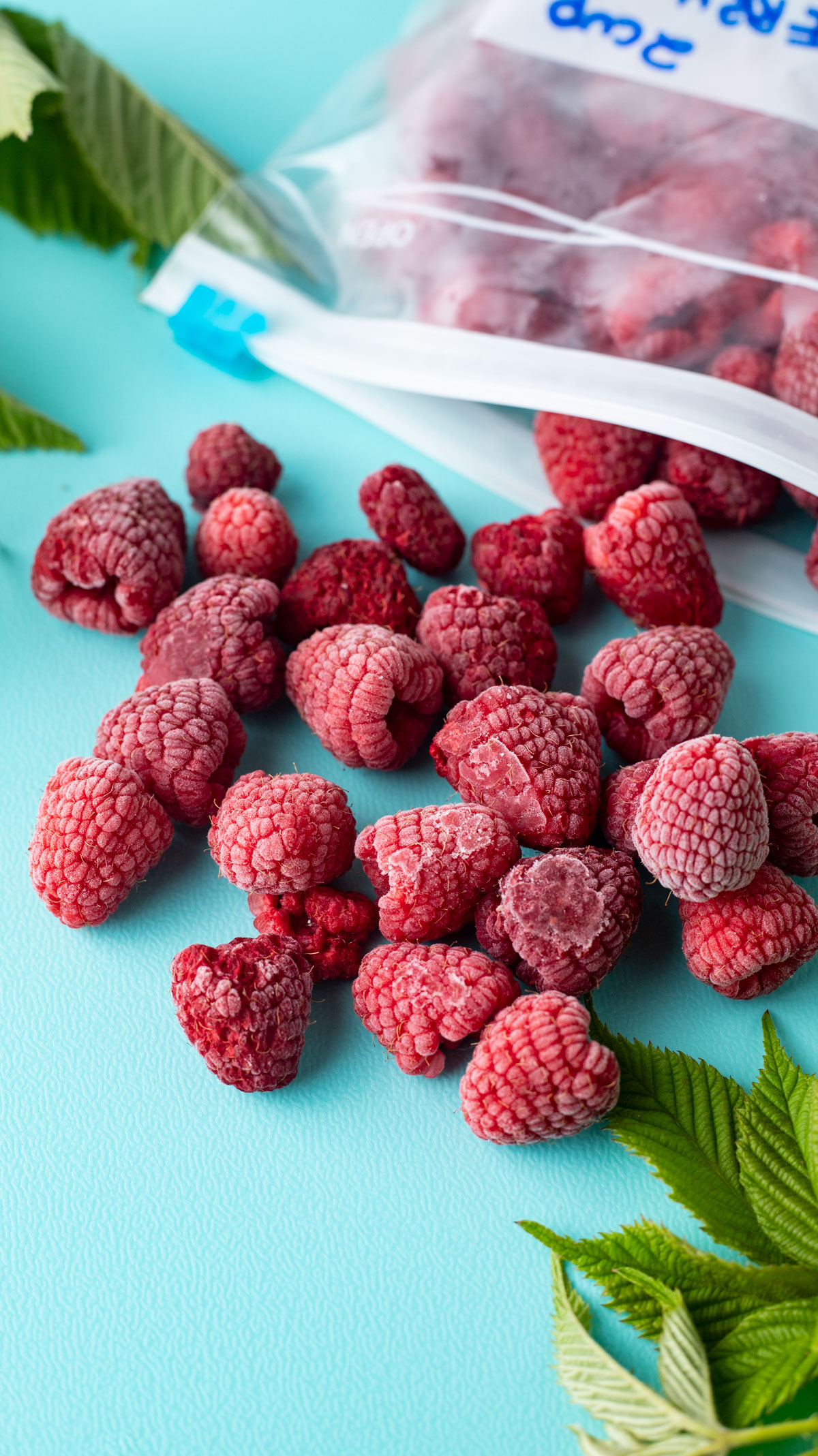 Frozen raspberries spilling out of freezer bag.
