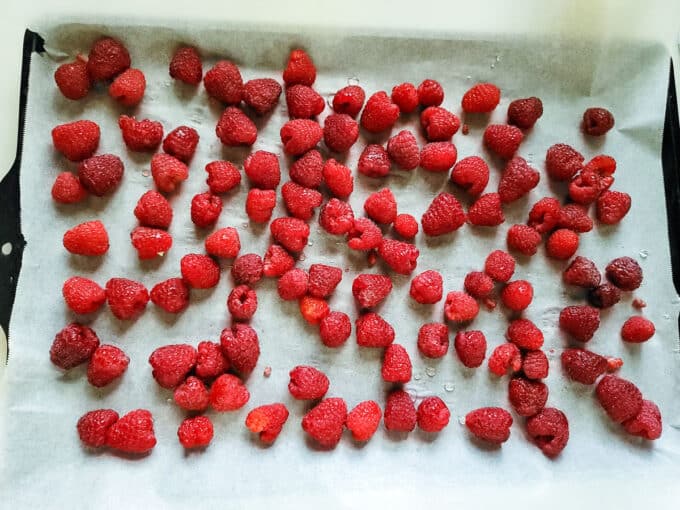 Berries spread out on baking sheet.
