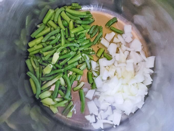 Scapes and onions in pot.