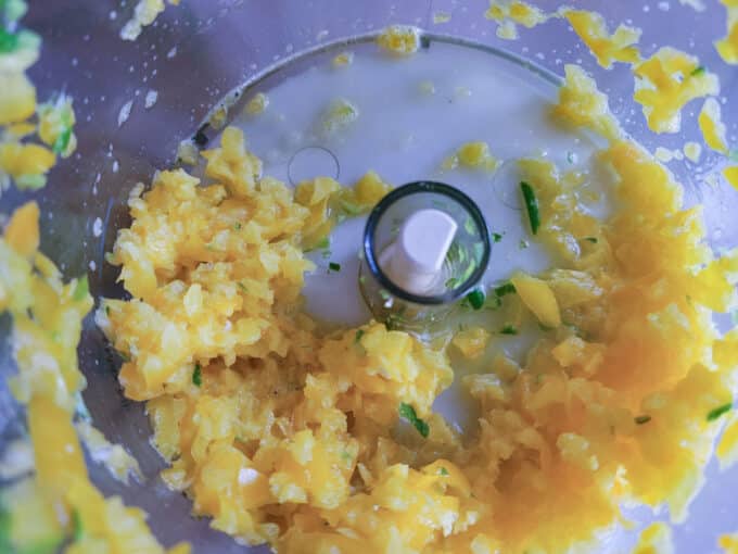 Chopped bell peppers in food processor bowl.