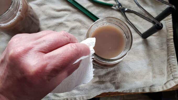 Wiping off rim of jar.