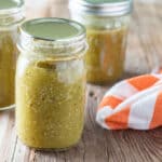 Tomatillo salsa in jars on barn wood background.