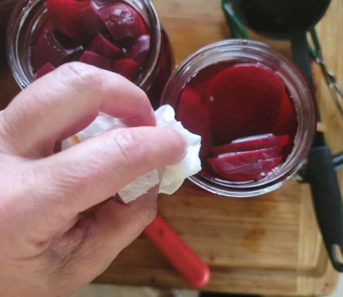 Wiping the rim of the jar clean.