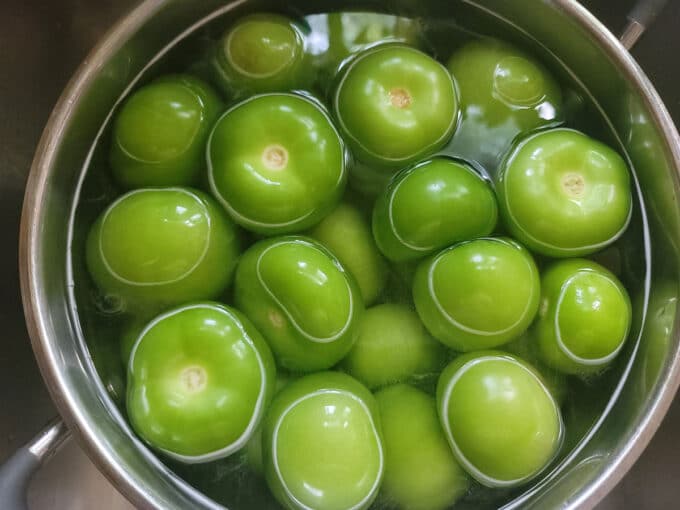 Fresh tomatillos in pot with water.