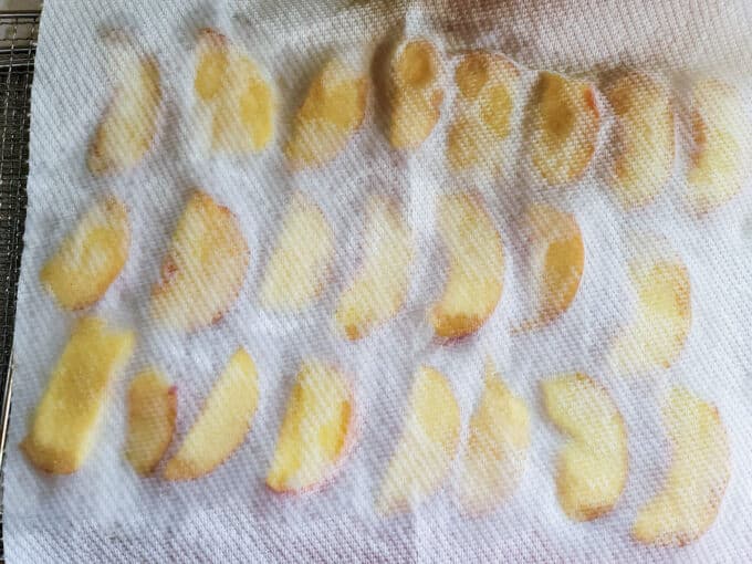 Peaches being dried off with paper towels.