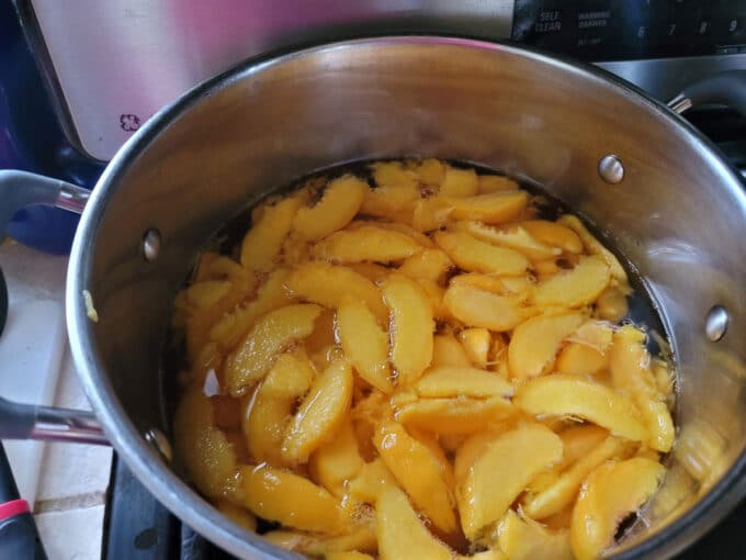 Sliced peaches in pot.