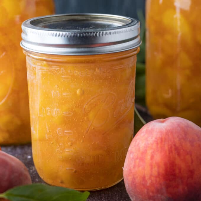 Pint jar of pie filling with fresh peaches.
