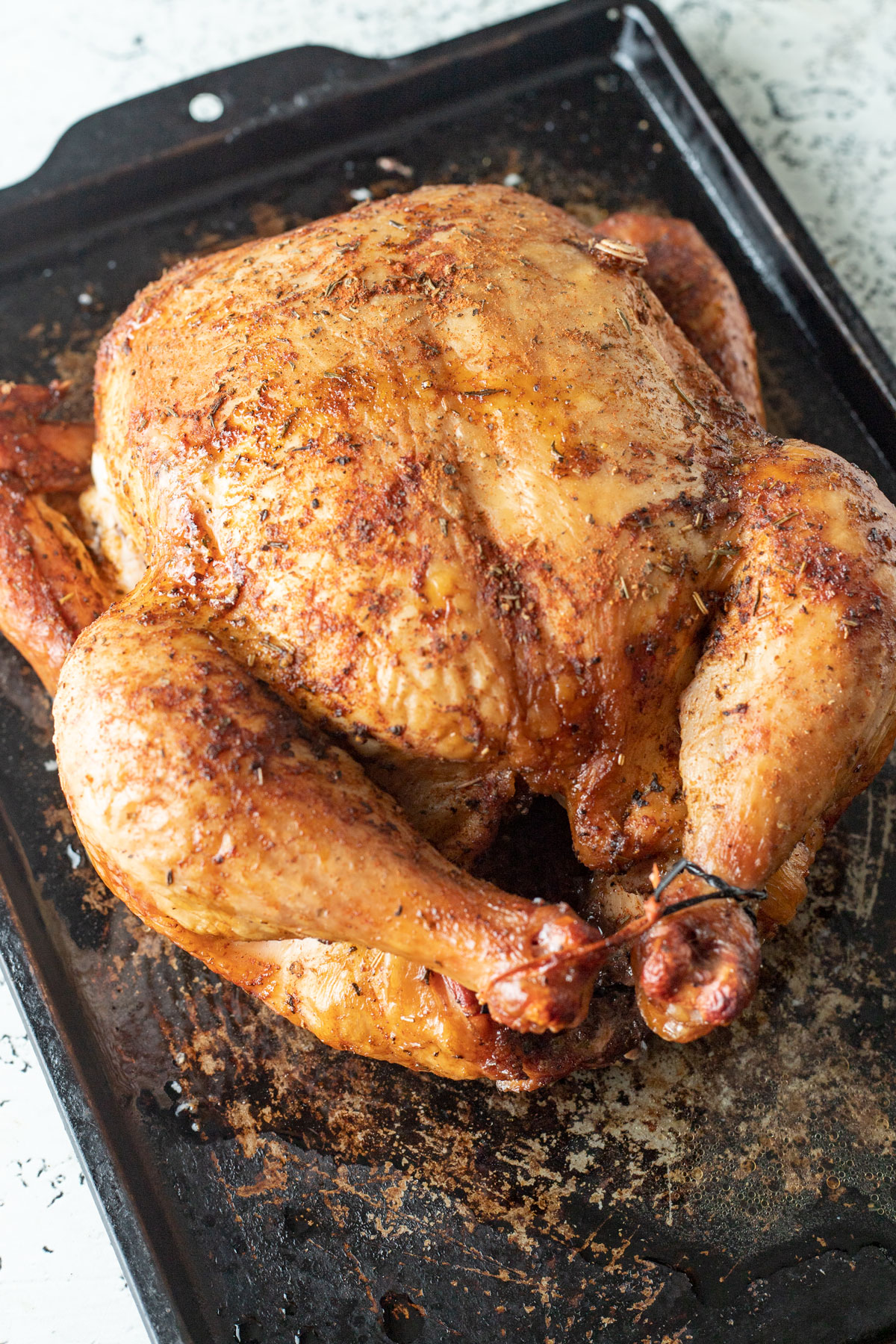 Whole chicken on metal tray.