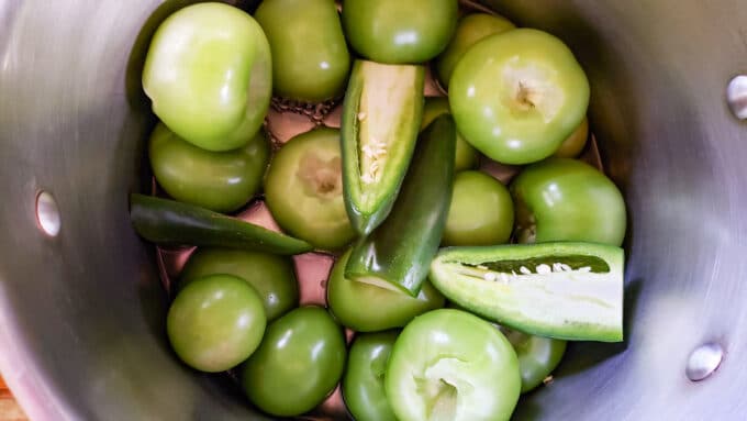 Tomatillos and peppers in large sauce pot.