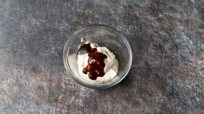 Mayonnaise and chipotle hot sauce in a small bowl.
