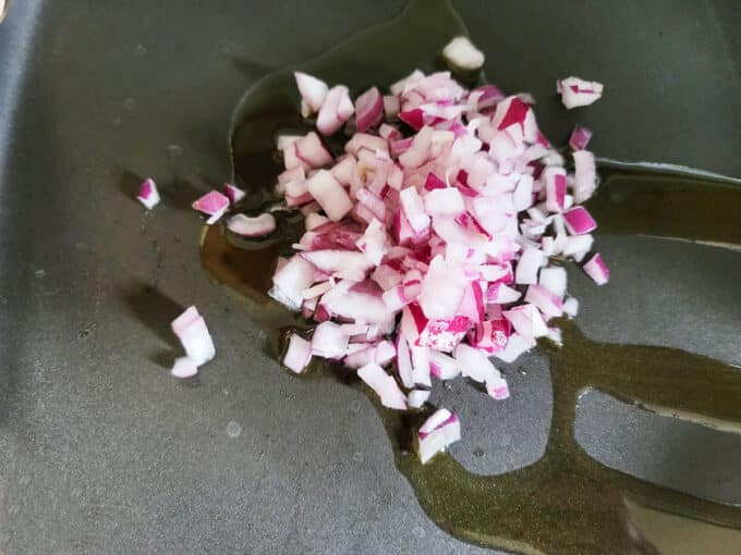 Red onions in a pan with olive oil.