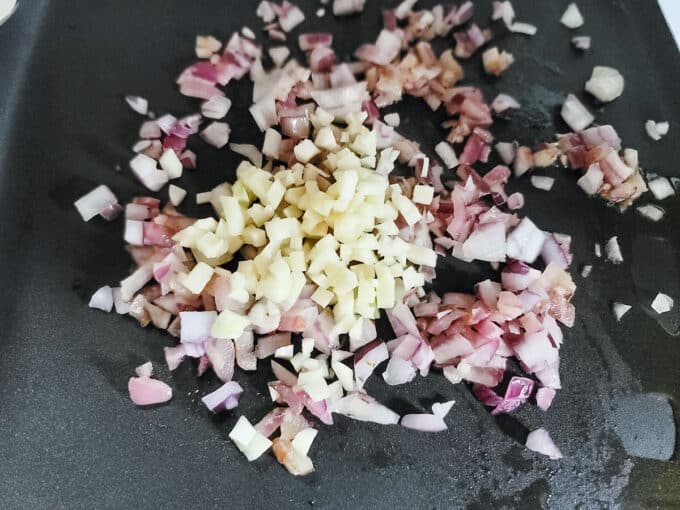 Garlic added to onions in pan.