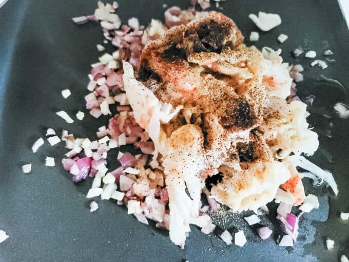 Lobster and spices added to pan.