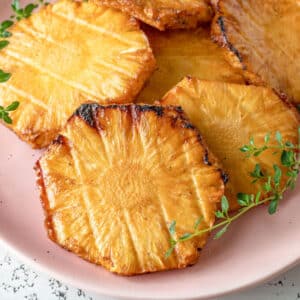 Pineapple piled on pink plate.