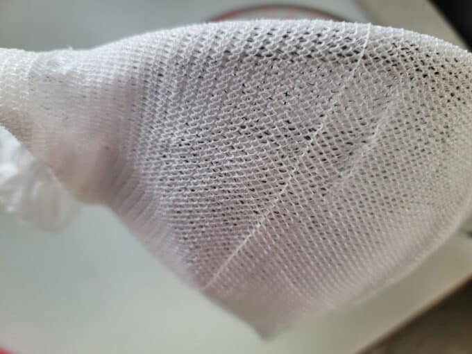 Fine mesh sieve with layers of cheesecloth.